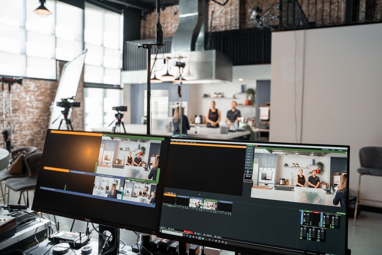 The Art of Drawing Readers In: Your attractive post title goes here A dynamic setup in a video production studio with two monitors and a kitchen setting.